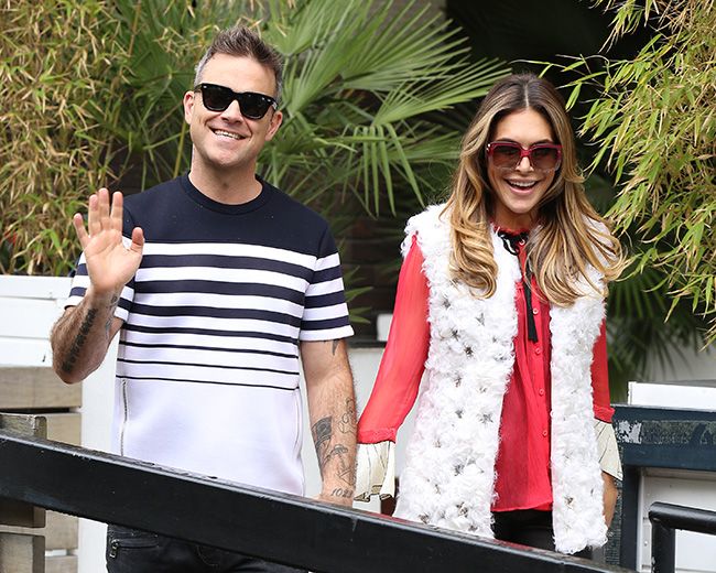 Robbie Williams and Ayda Field holding hands, laughing