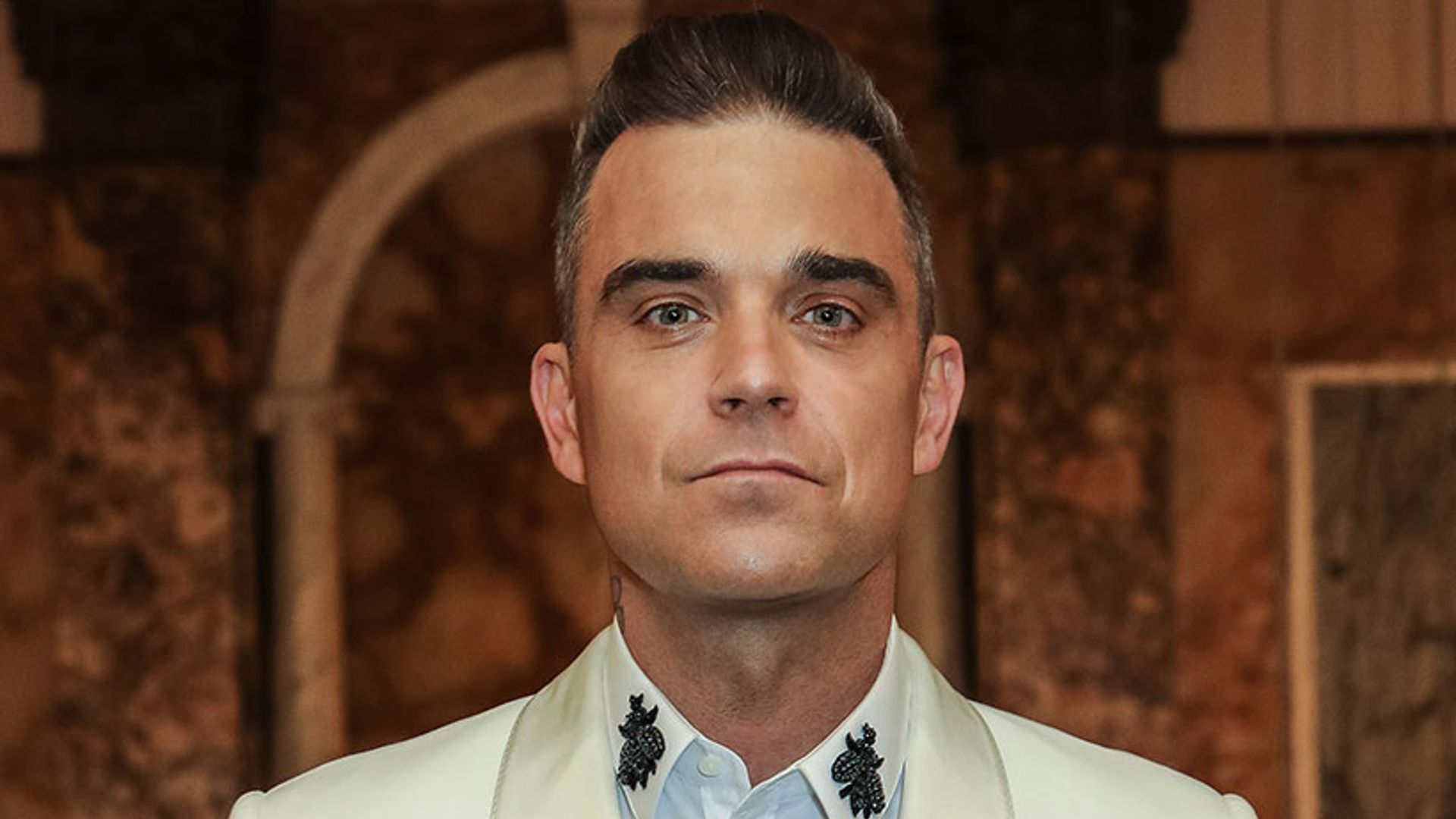 Robbie Williams reveals younger new look - see pictures