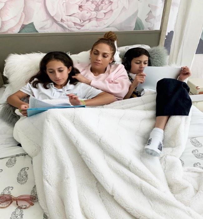 Jennifer Lopez relaxes in bed with her twins Emme and max