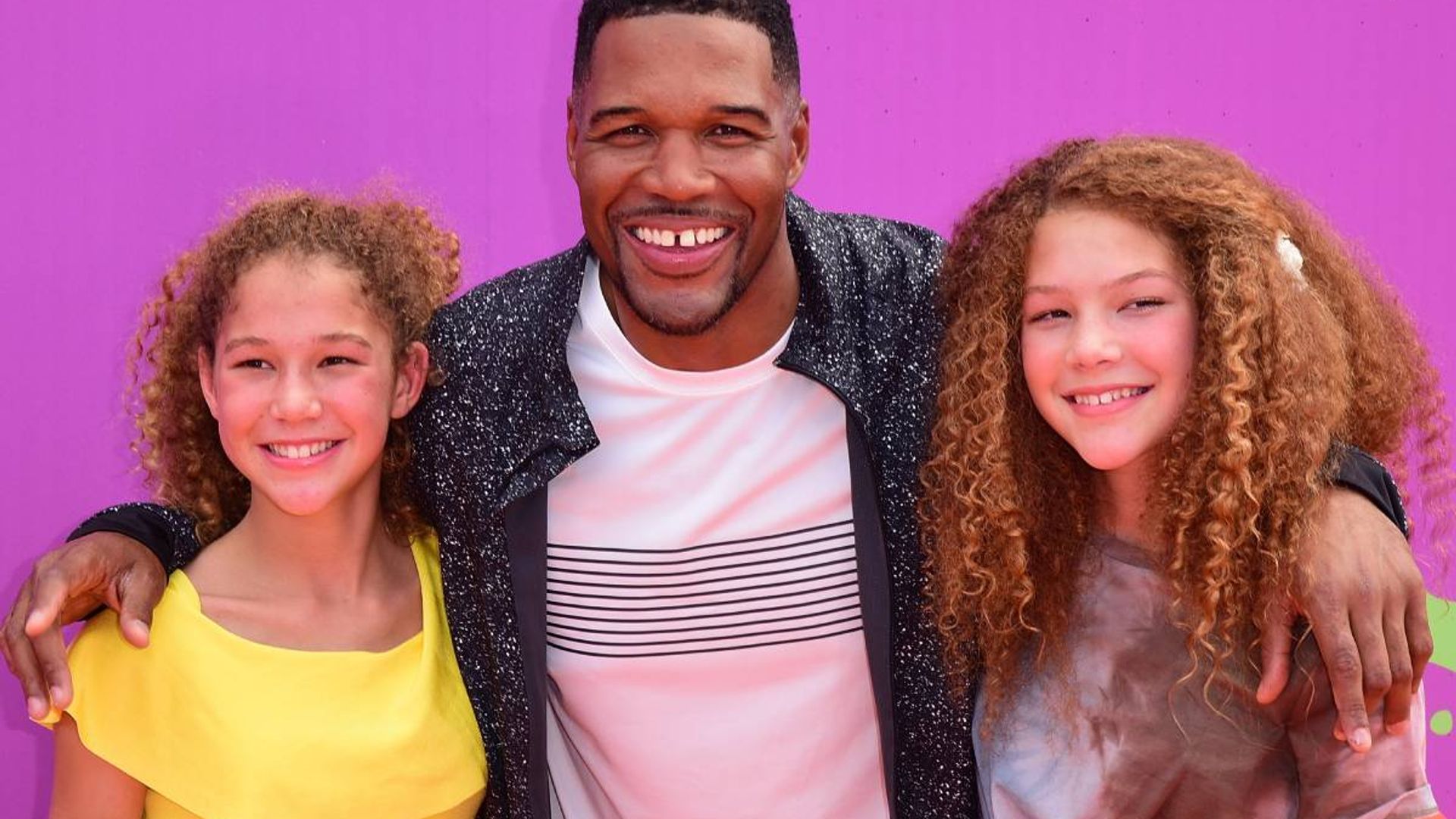 Michael Strahan's twins steal the show as they model famous dad's collection