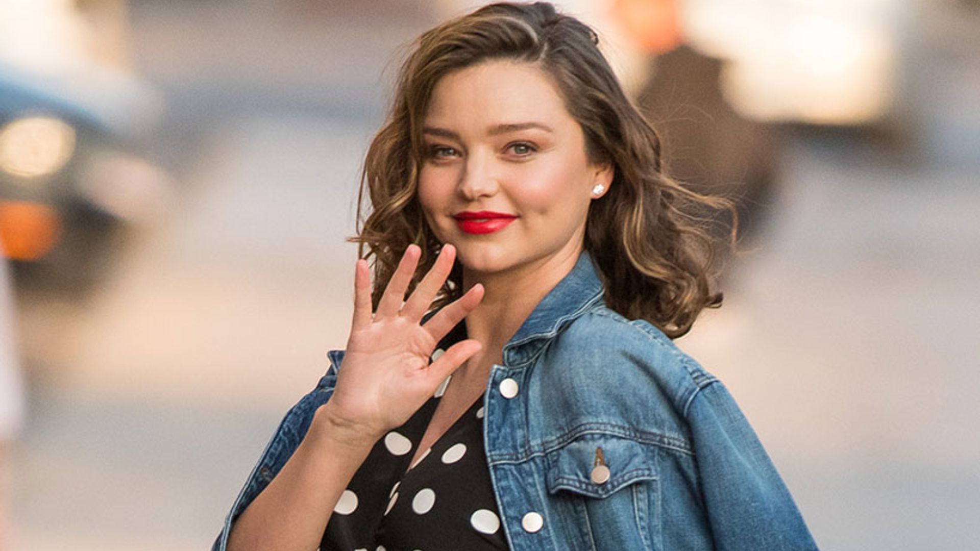 Miranda Kerr looks every inch the doting mother as she cradles blossoming baby bump